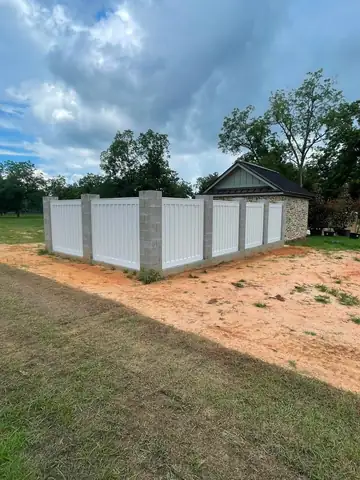 White vinyl privacy fence along a residential lot line