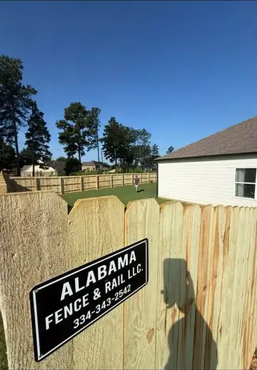 Alabama Fence & Rail yard sign mounted on a finished wood privacy fence
