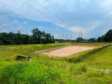 Fenced retention pond on a graded site