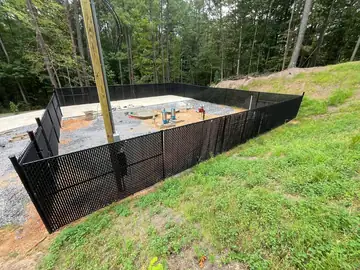 Black safety fencing set on a graded construction slope