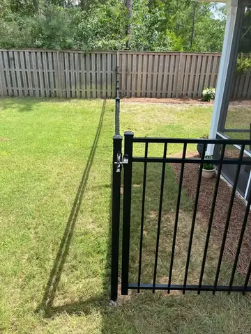 Black aluminum walk gate in a back yard