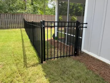 Black aluminum fence returning to the corner of a house