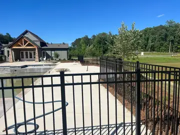 Black aluminum fence around a pool deck and patio