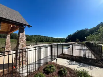 Black aluminum fence beside a stone pool pavilion