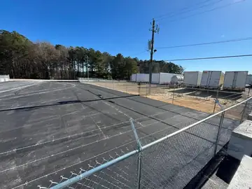 Chain link security fence with barbed arms at a storage facility