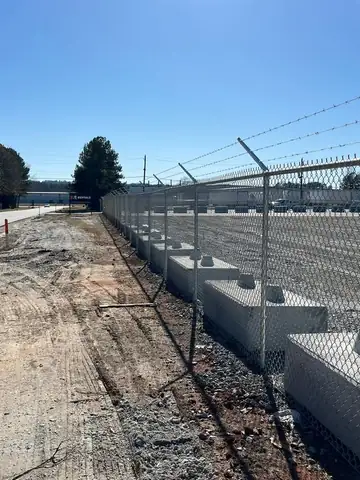 New security fence line beside concrete barriers