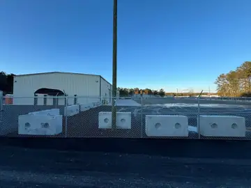 Storage buildings behind a galvanized perimeter fence