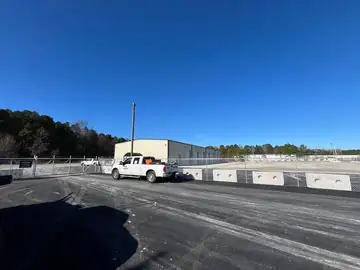 Perimeter fence along the asphalt edge of a storage facility