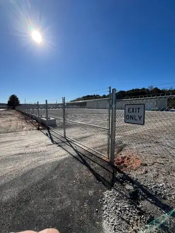 Chain link gate with an exit-only sign at a commercial yard