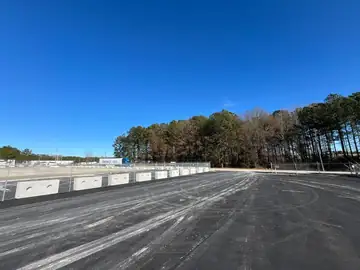 Asphalt yard enclosed by commercial fencing
