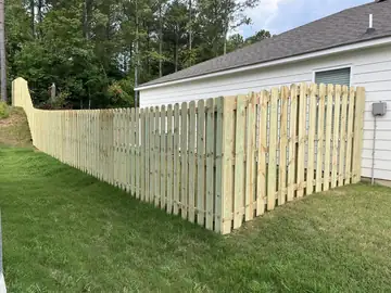 Spaced picket fence along the side of a house