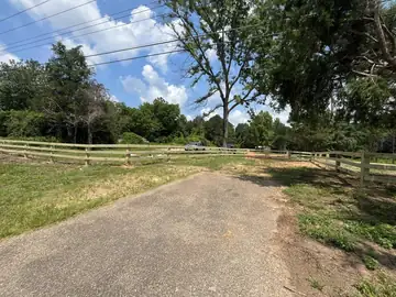 Split rail fence beside a gravel drive