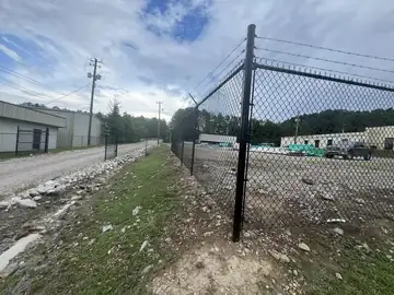 Black chain link fence line at an industrial lot
