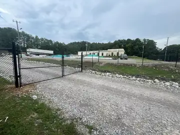 Black chain link fence and gate on a gravel drive