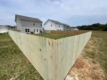 Wood privacy fence corner behind new houses
