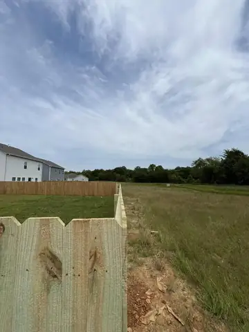 Wood privacy fence running across a graded back yard