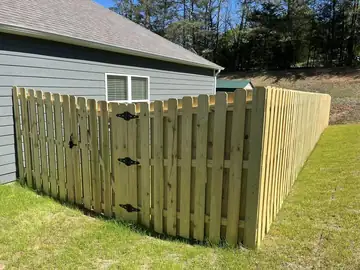 Wood privacy fence and gate returning to a house wall