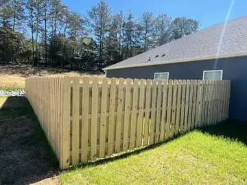 Spaced picket fence around a back yard
