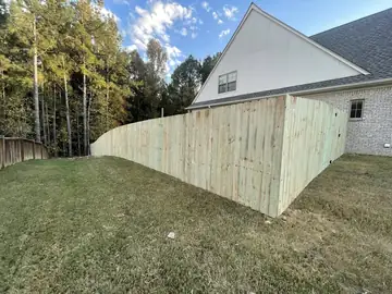 Wood privacy fence following the grade behind a house