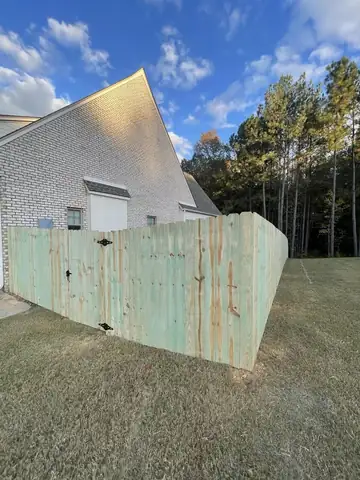 Wood privacy fence returning to a brick house