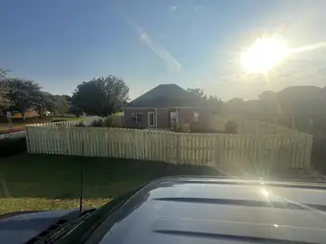 Wood privacy fence at sunset behind a house