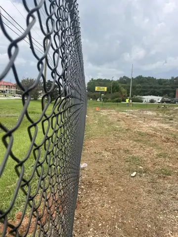 Black chain link fence beside a roadway
