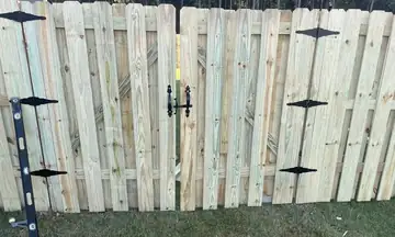 Wood privacy gate with black strap hinges