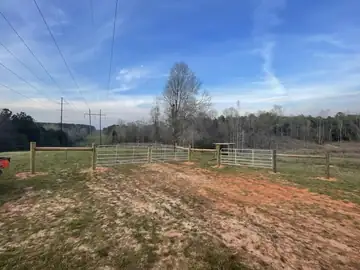 Farm gate and wire fence on cleared ground