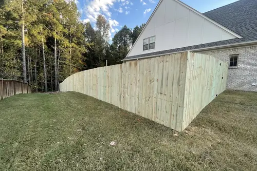 Wood privacy fence following the grade behind a house