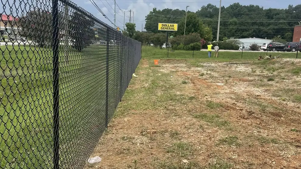 Black chain link fence line across open Alabama ground