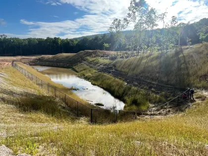 Black safety fencing installed on a graded construction slope for erosion control