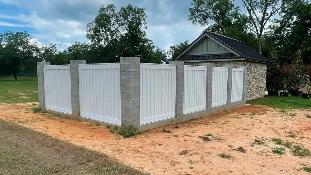 White vinyl privacy fence panels installed along a residential lot line